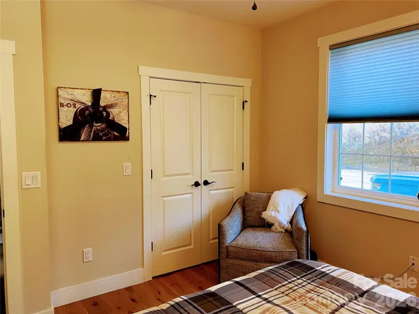 a bedroom with a chair and window