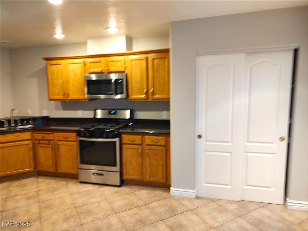 2223 Rugged Mesa Drive Laughlin, NV 89029 - Photo 7 of 28 Kitchen with brown cabinets, dark countertops, sta