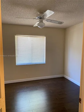 a view of an empty room with wooden floor and closet