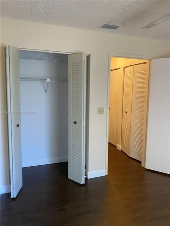 a view of empty room with wooden floor and ceiling fan