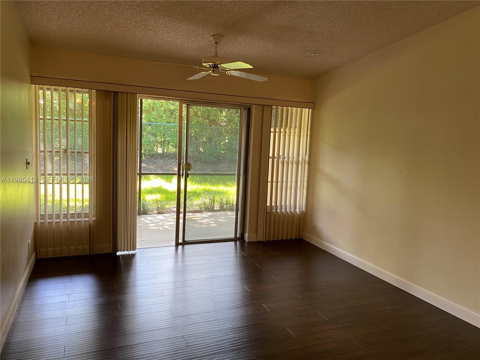 18595 Egret Way, Unit 18595 Boca Raton, FL 33496 - Photo 26 of 66 an empty room with wooden floor and windows