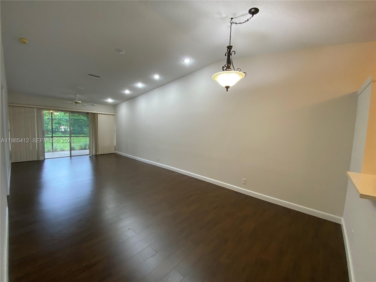 18595 Egret Way, Unit 18595 Boca Raton, FL 33496 - Photo 40 of 66 an empty room with wooden floor and windows