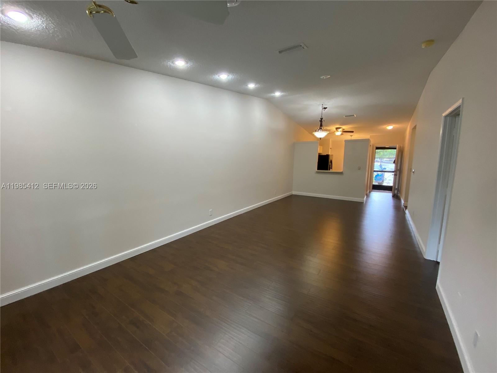 18595 Egret Way, Unit 18595 Boca Raton, FL 33496 - Photo 45 of 66 an empty room with wooden floor and windows