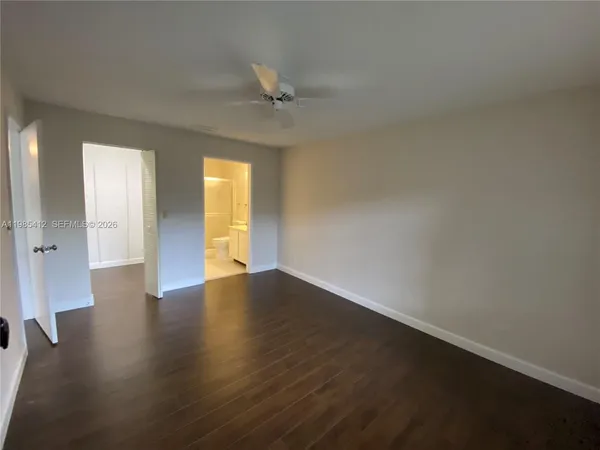 an empty room with wooden floor and door