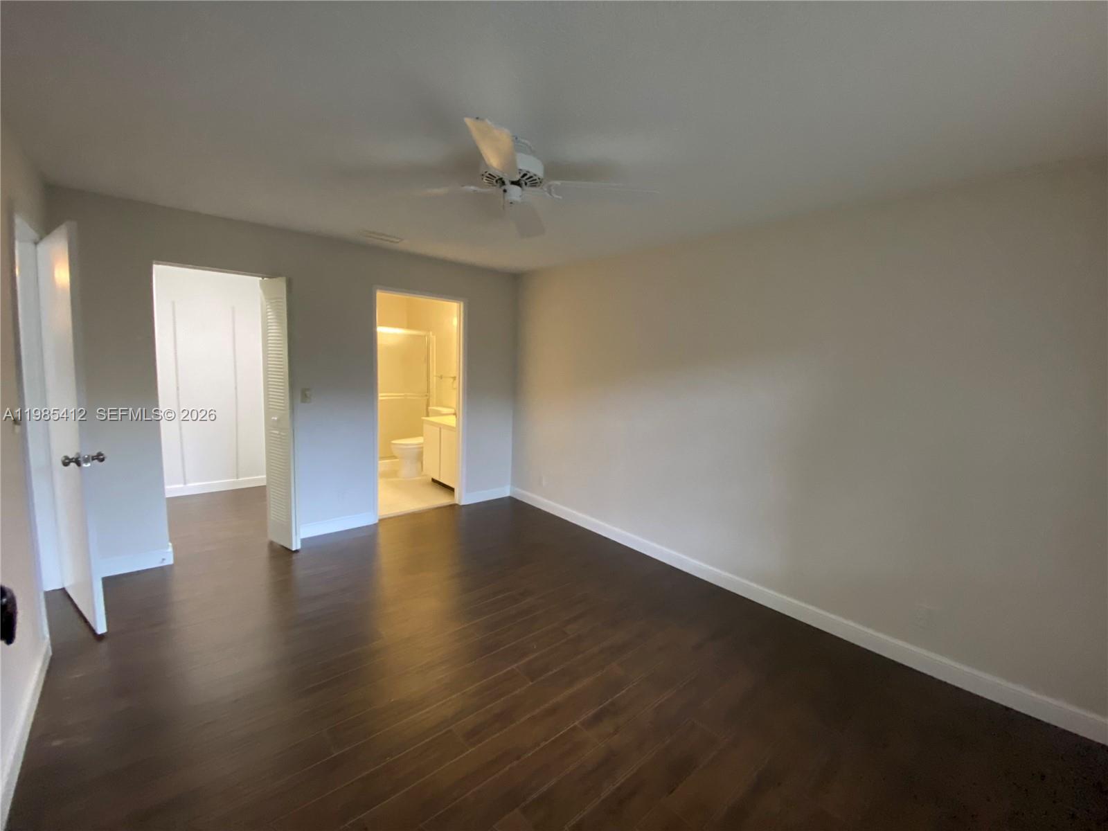 18595 Egret Way, Unit 18595 Boca Raton, FL 33496 - Photo 48 of 66 an empty room with wooden floor and windows