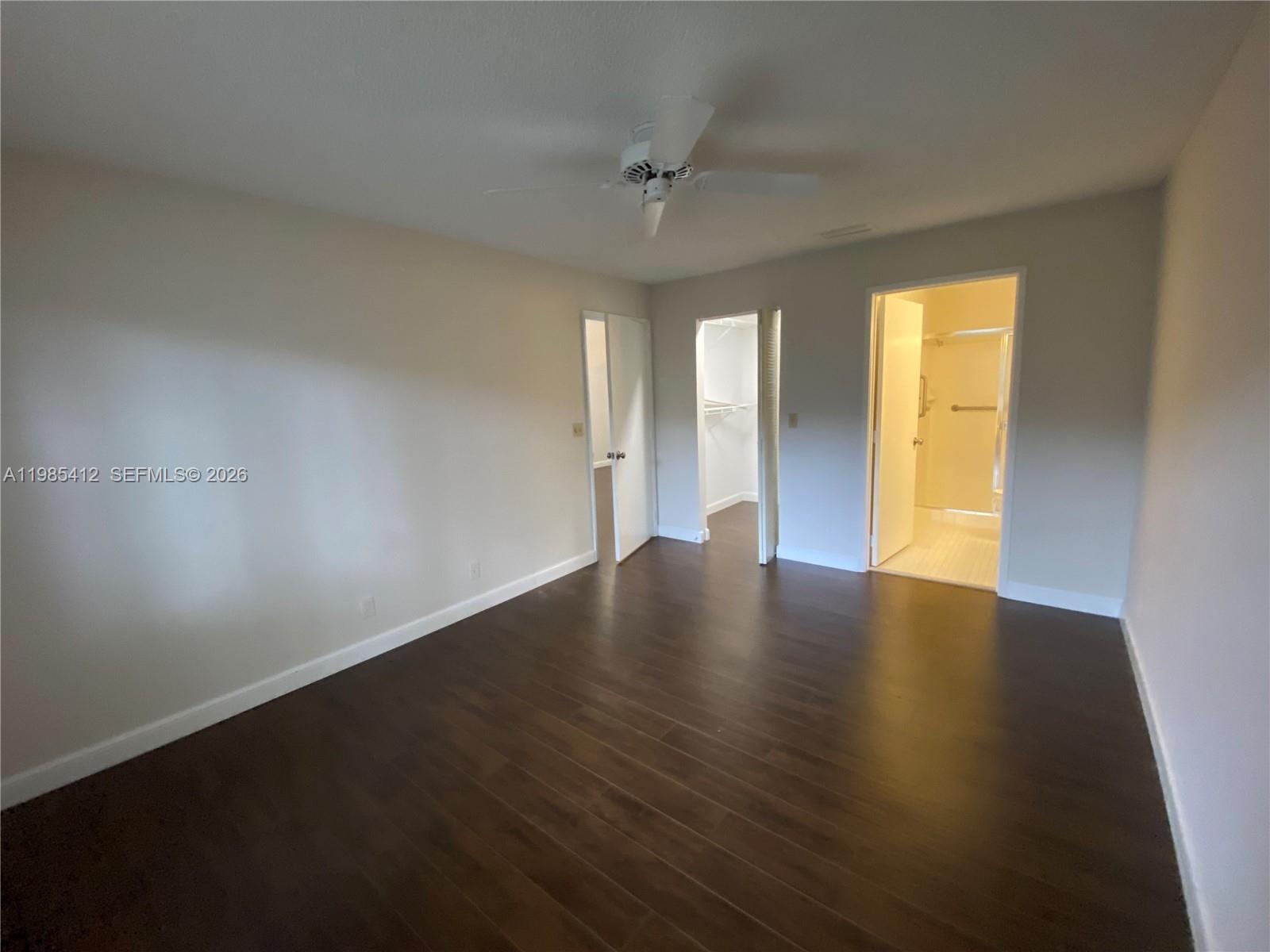 18595 Egret Way, Unit 18595 Boca Raton, FL 33496 - Photo 49 of 66 an empty room with wooden floor and windows