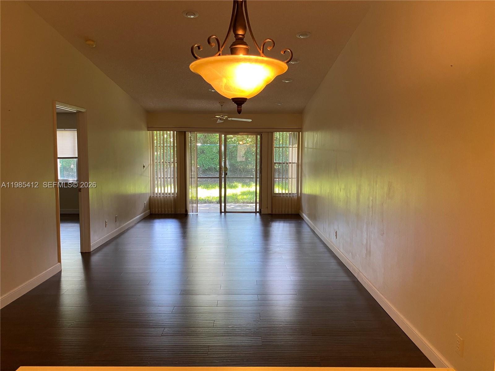 18595 Egret Way, Unit 18595 Boca Raton, FL 33496 - Photo 5 of 66 a view of a hallway with wooden floor and a chandelier