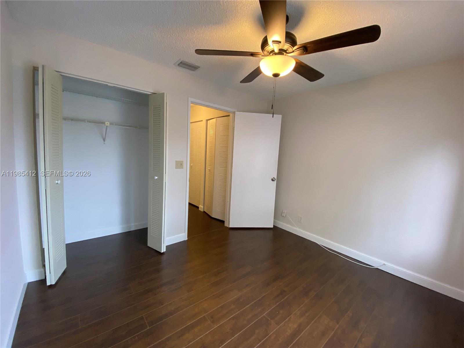 18595 Egret Way, Unit 18595 Boca Raton, FL 33496 - Photo 51 of 66 an empty room with wooden floor fan and windows