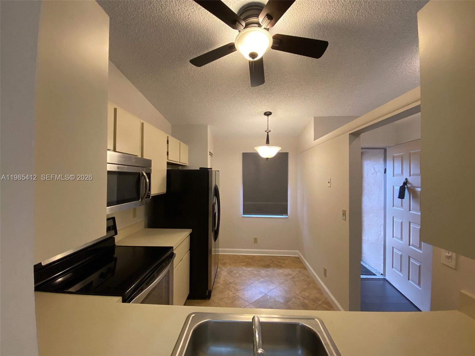 18595 Egret Way, Unit 18595 Boca Raton, FL 33496 - Photo 53 of 66 a view of kitchen with a sink and refrigerator