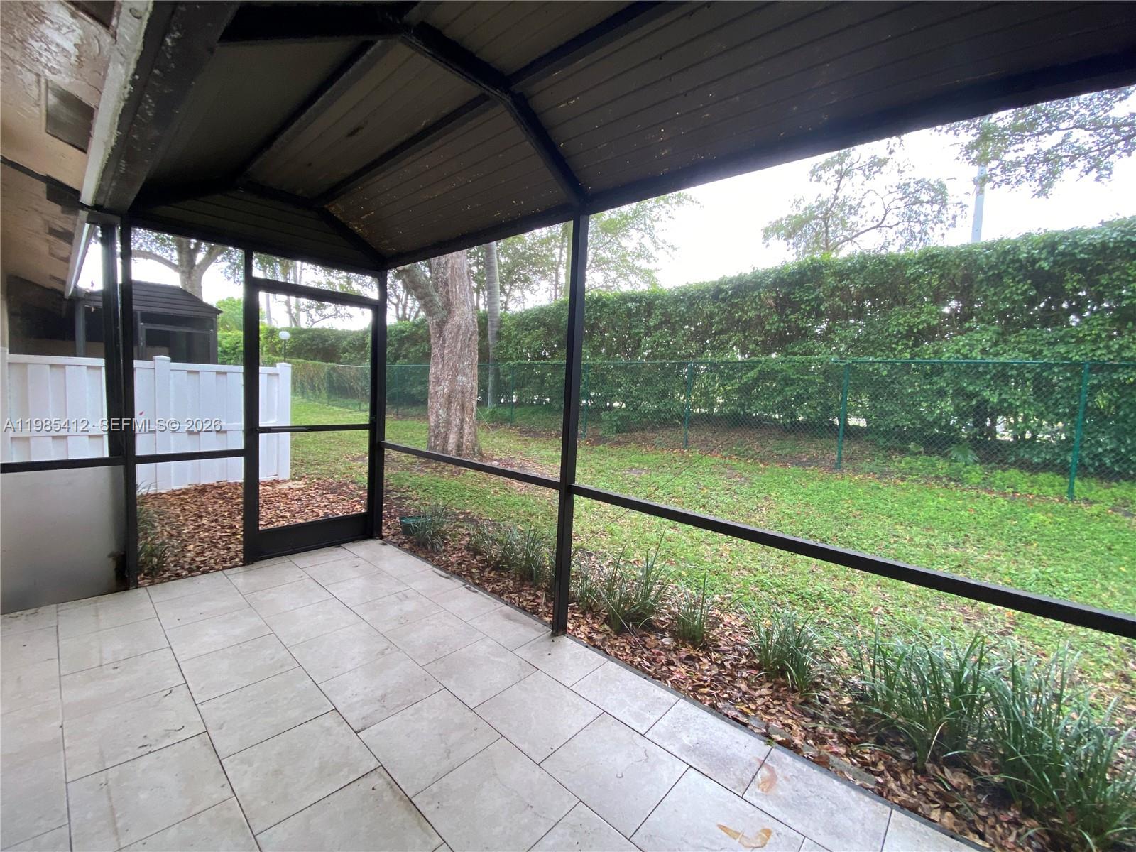 18595 Egret Way, Unit 18595 Boca Raton, FL 33496 - Photo 55 of 66 a view of a floor to ceiling window next to a yard