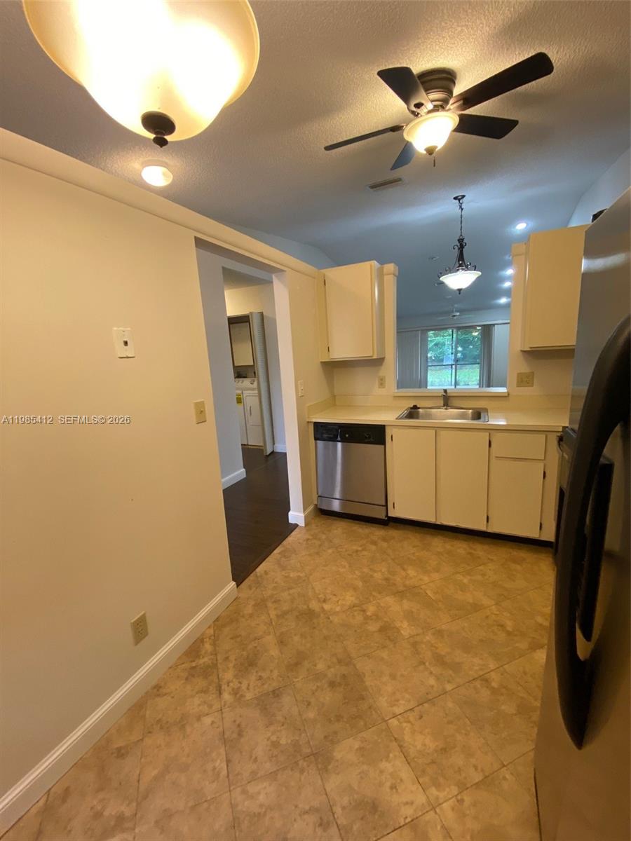18595 Egret Way, Unit 18595 Boca Raton, FL 33496 - Photo 56 of 66 a view of a kitchen with a sink and a refrigerator