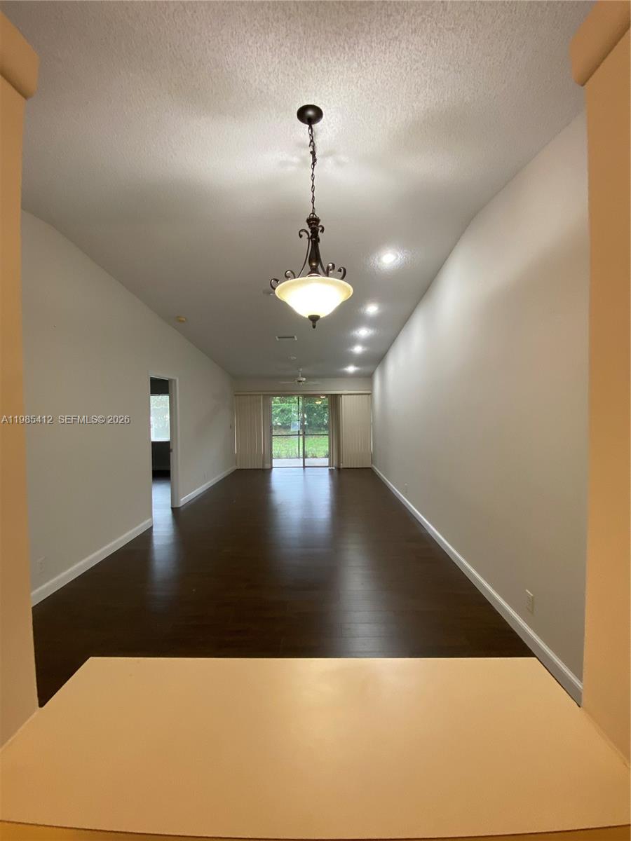 18595 Egret Way, Unit 18595 Boca Raton, FL 33496 - Photo 57 of 66 a view of a room with a chandelier wooden floor and a ceiling fan