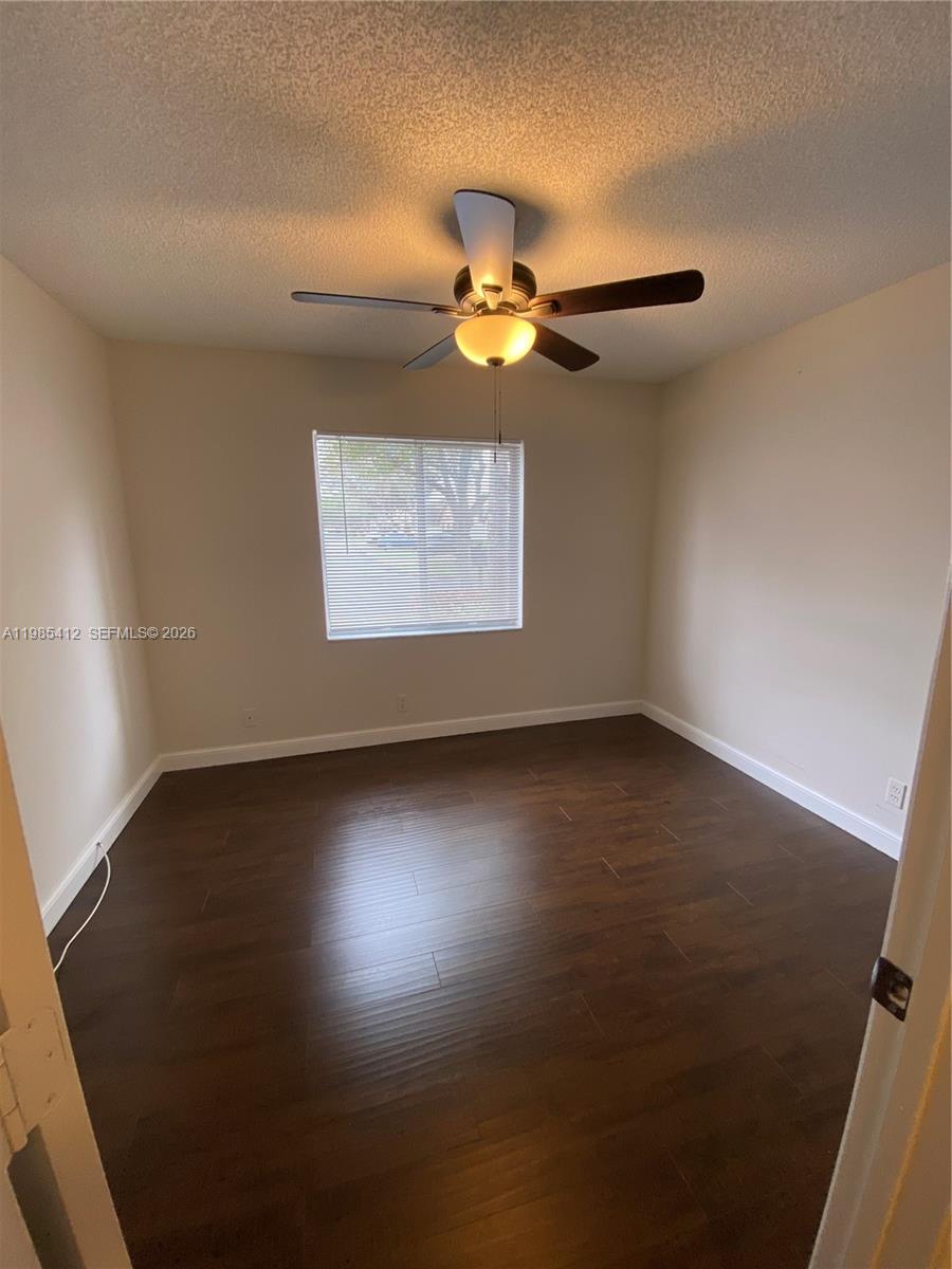 18595 Egret Way, Unit 18595 Boca Raton, FL 33496 - Photo 60 of 66 an empty room with wooden floor and windows