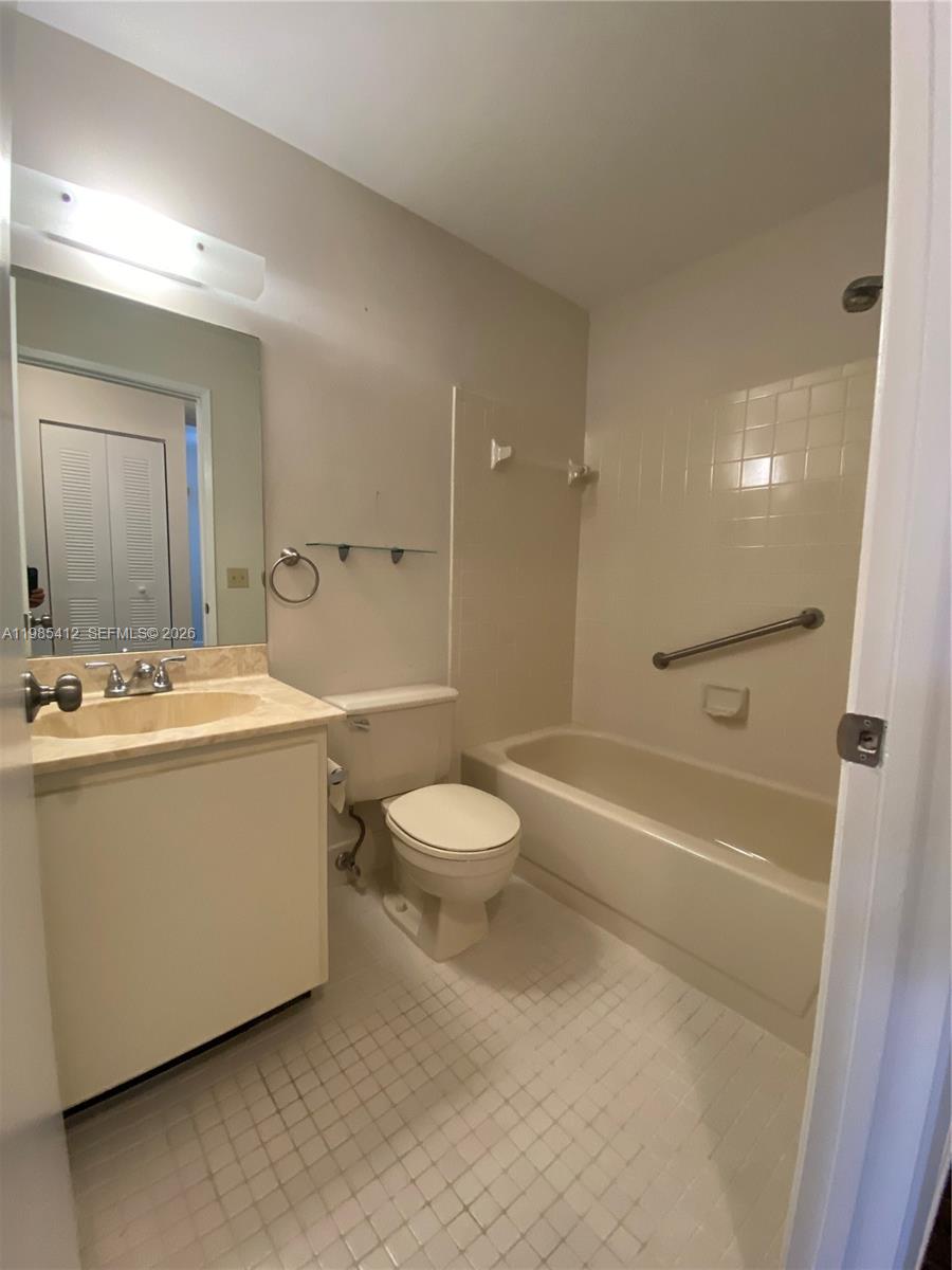18595 Egret Way, Unit 18595 Boca Raton, FL 33496 - Photo 61 of 66 a bathroom with a sink a toilet and a large mirror