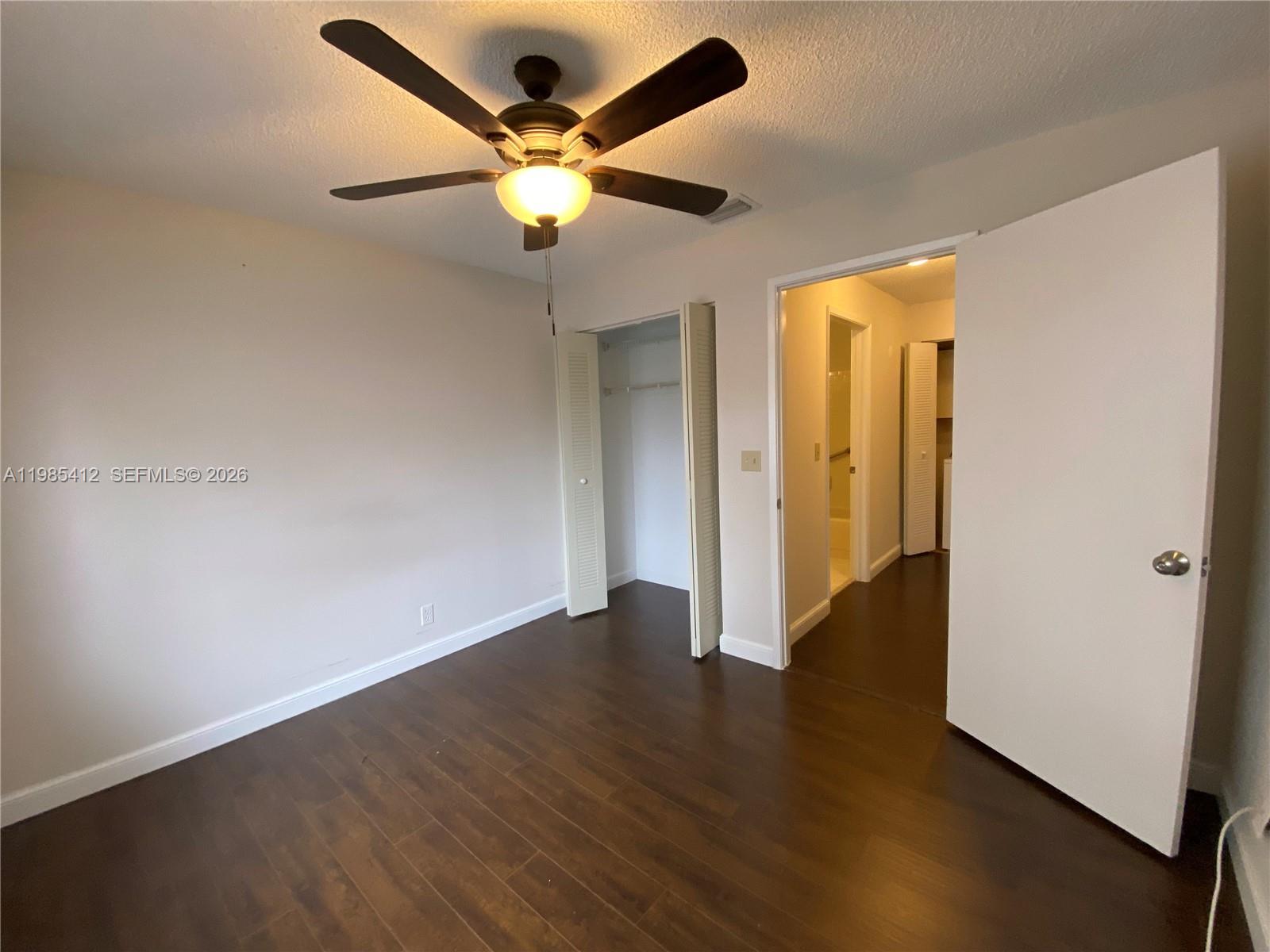 18595 Egret Way, Unit 18595 Boca Raton, FL 33496 - Photo 62 of 66 an empty room with wooden floor and door