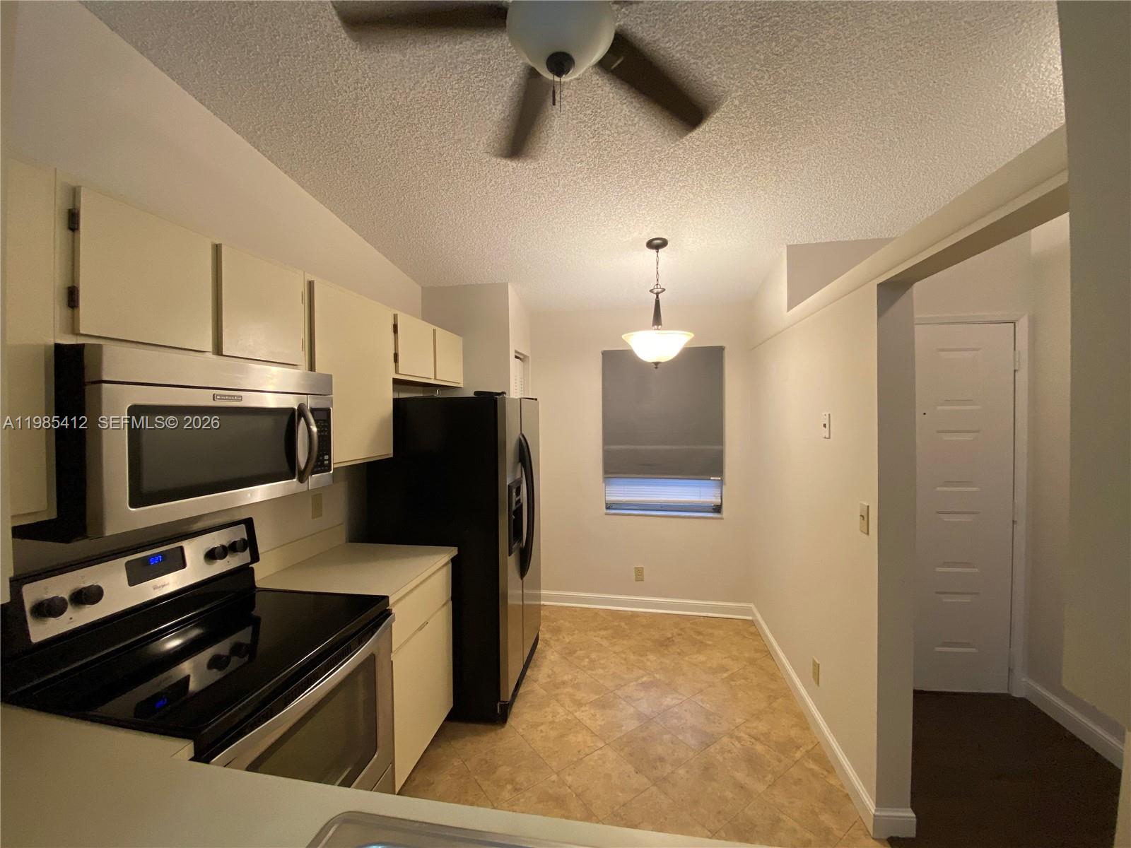 18595 Egret Way, Unit 18595 Boca Raton, FL 33496 - Photo 9 of 66 a kitchen with stainless steel appliances a refrigerator a stove a microwave and cabinets