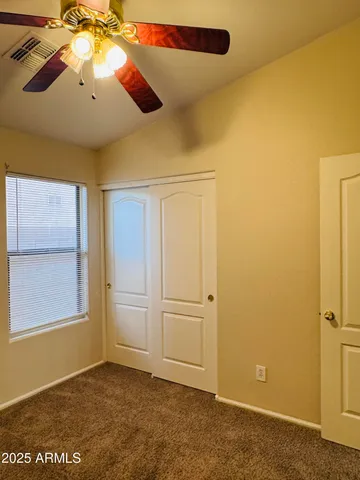 an empty room with windows and fan