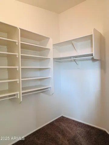 a view of walk in closet with empty racks