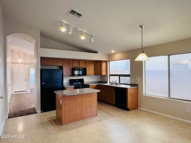 a kitchen with stainless steel appliances kitchen island a refrigerator sink and microwave