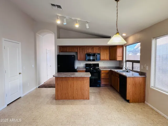 a large kitchen with stainless steel appliances granite countertop a stove and a refrigerator