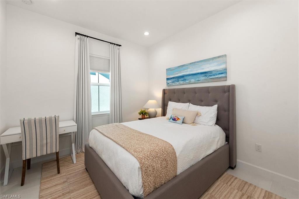 7315 Cayo Coco Lane Naples, FL 34113 - Photo 16 of 30 a bedroom with a bed and chair