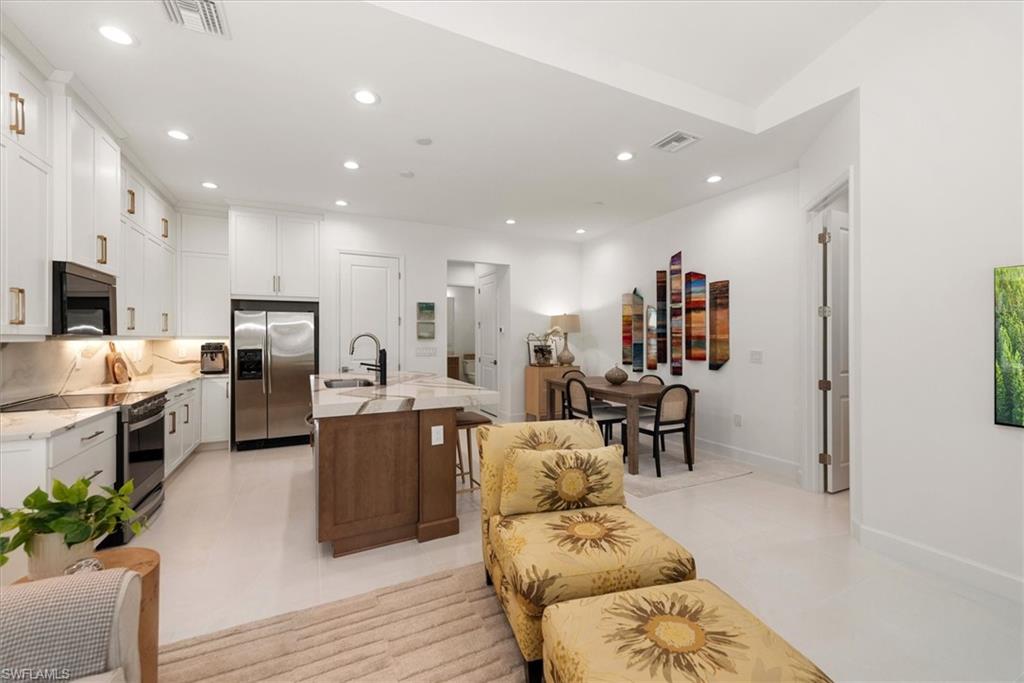 7315 Cayo Coco Lane Naples, FL 34113 - Photo 5 of 30 a living room with stainless steel appliances furniture and a kitchen view
