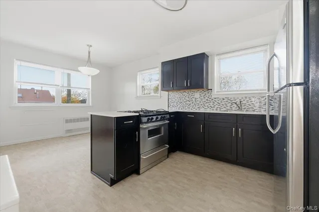 a kitchen with stainless steel appliances granite countertop a stove a sink and a microwave