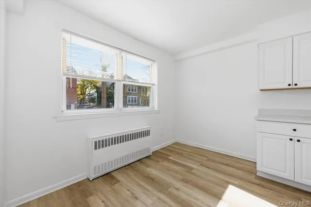 a view of a hallway with wooden floor and closet