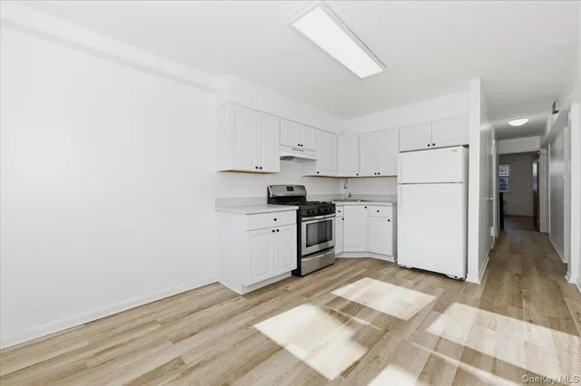 a kitchen with a refrigerator and a stove top oven