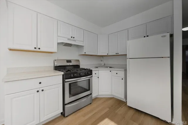 a kitchen with white cabinets and white appliances