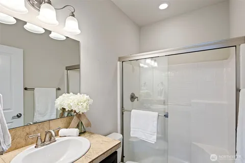 a bathroom with a sink shower and a mirror