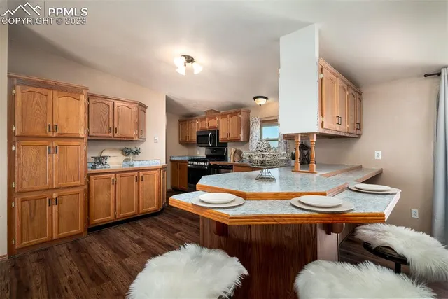 a kitchen with stainless steel appliances granite countertop a sink a stove a refrigerator and wooden cabinets