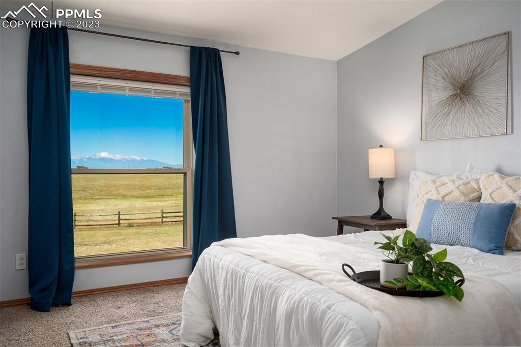 5695 Peerless Farms Road Peyton, CO 80831 - Photo 22 of 50 a bedroom with a bed and a painting on the wall