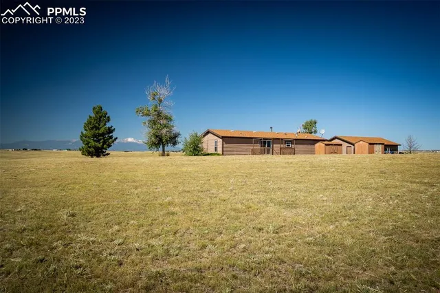 a view of a house with a wooden fence