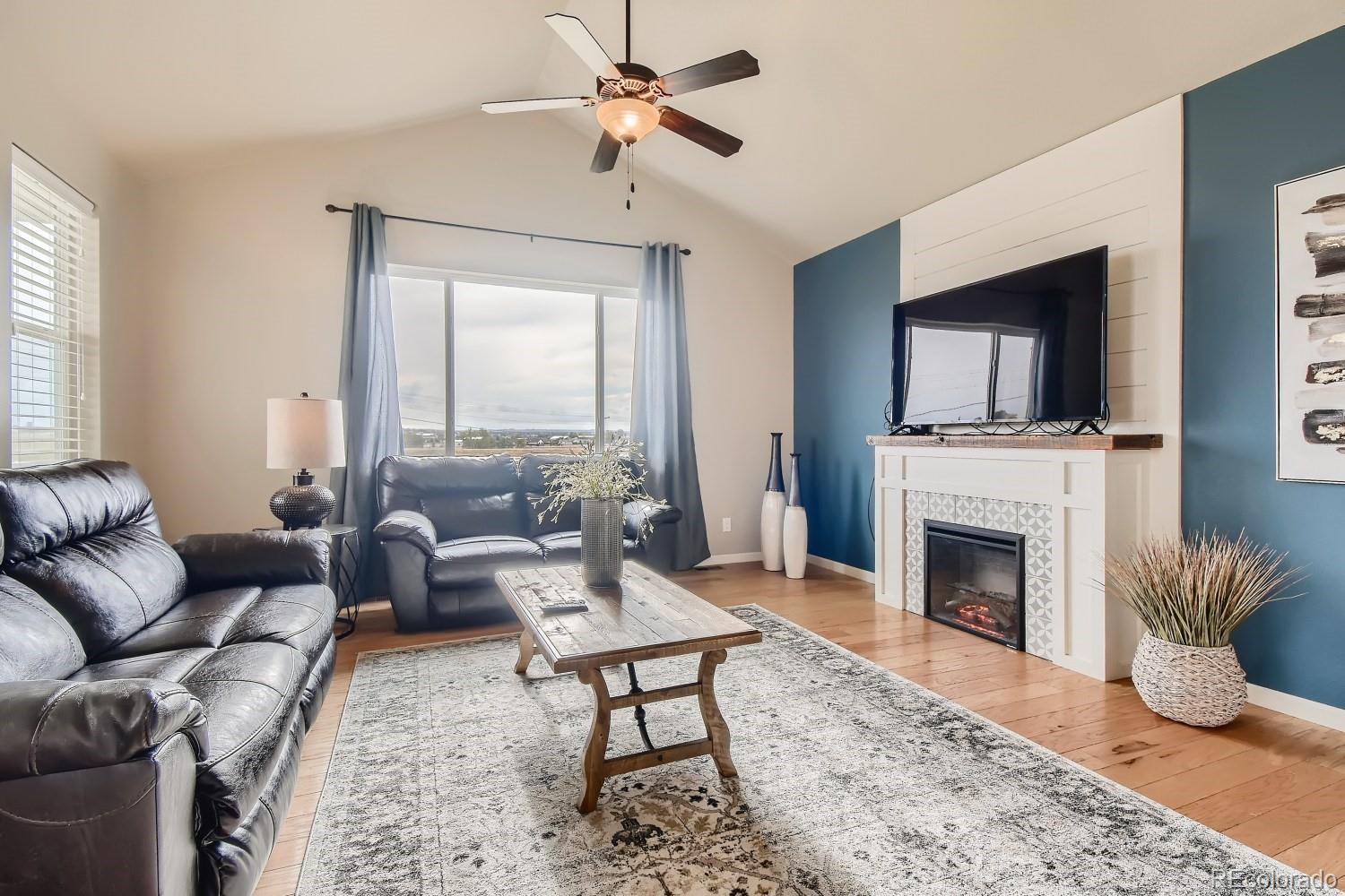 16035 Newark Lane Brighton, CO 80602 - Photo 12 of 40 a living room with furniture a fireplace and a flat screen tv