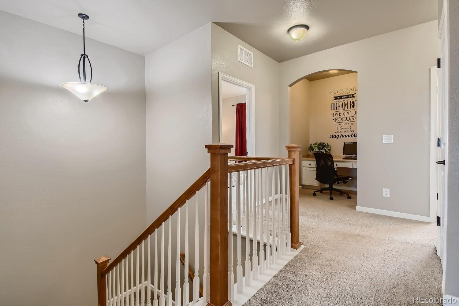 16035 Newark Lane Brighton, CO 80602 - Photo 17 of 40 a view of a hallway with a livingroom and stairs