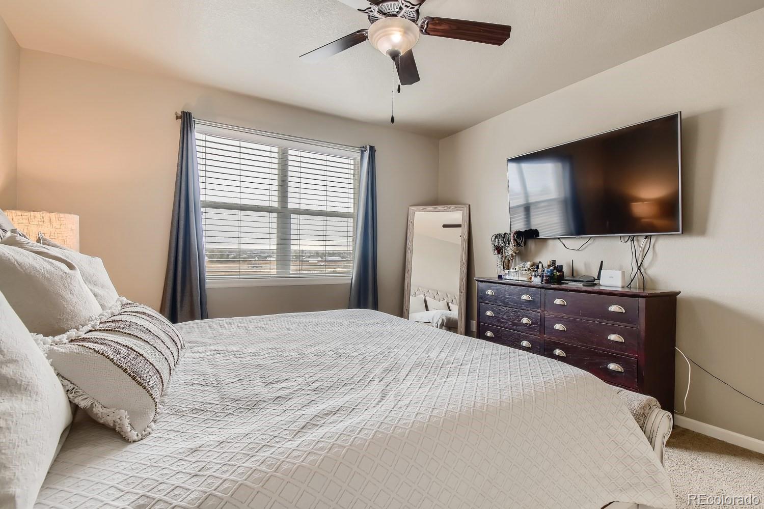 16035 Newark Lane Brighton, CO 80602 - Photo 20 of 40 a bedroom with a bed and a flat screen tv