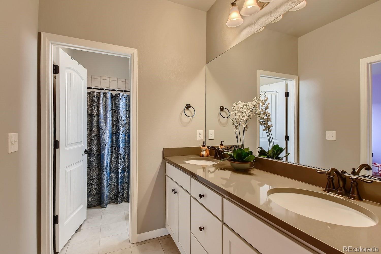 16035 Newark Lane Brighton, CO 80602 - Photo 26 of 40 a bathroom with a granite countertop sink and a mirror