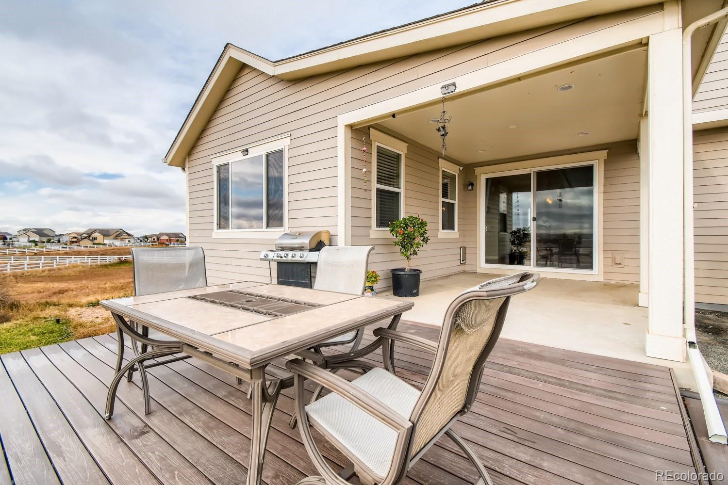 16035 Newark Lane Brighton, CO 80602 - Photo 32 of 40 a view of a patio with couches and table and chairs with wooden floor