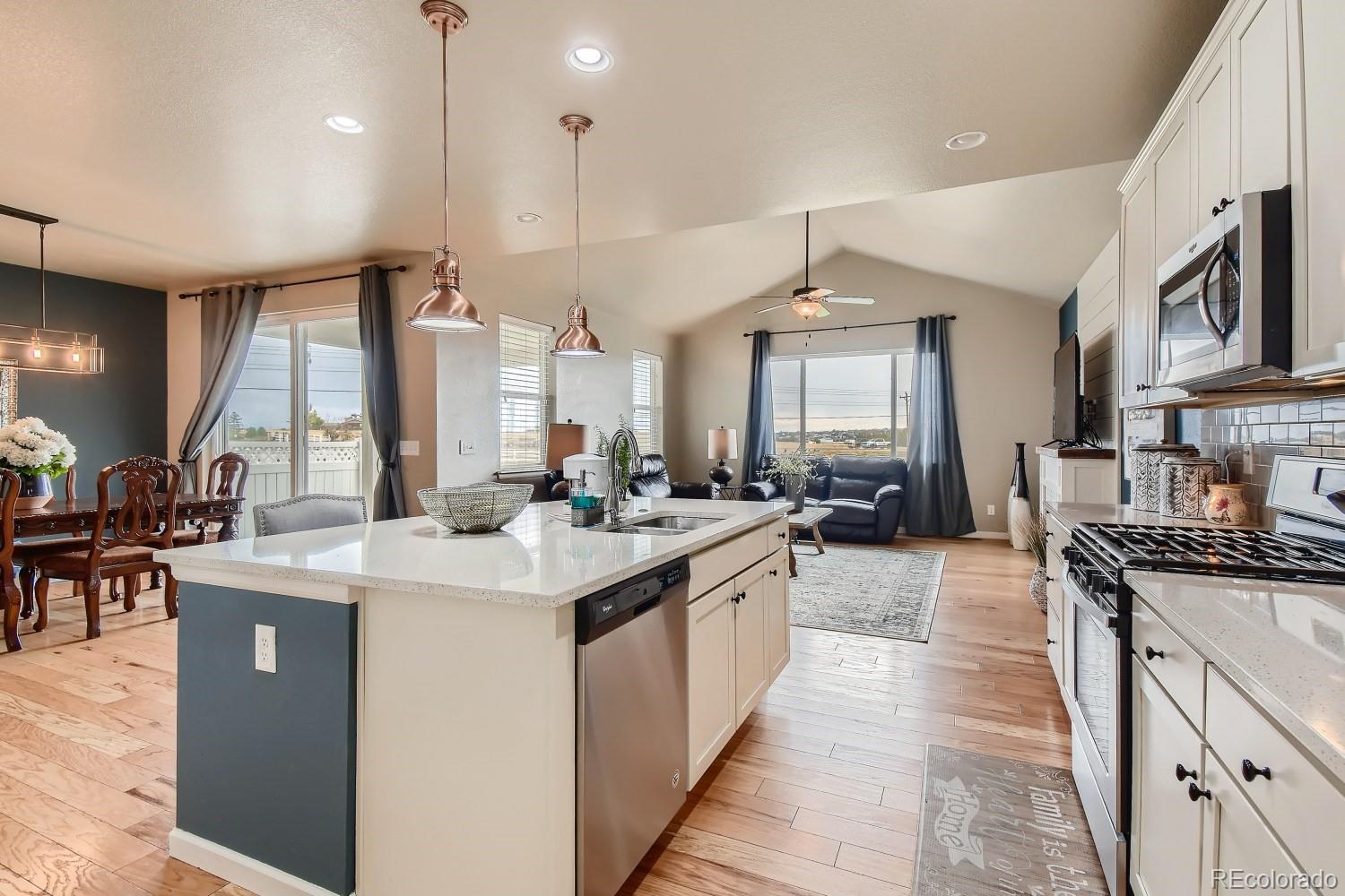 16035 Newark Lane Brighton, CO 80602 - Photo 9 of 40 a large kitchen with stainless steel appliances kitchen island granite countertop a large counter top couches and a view of living room