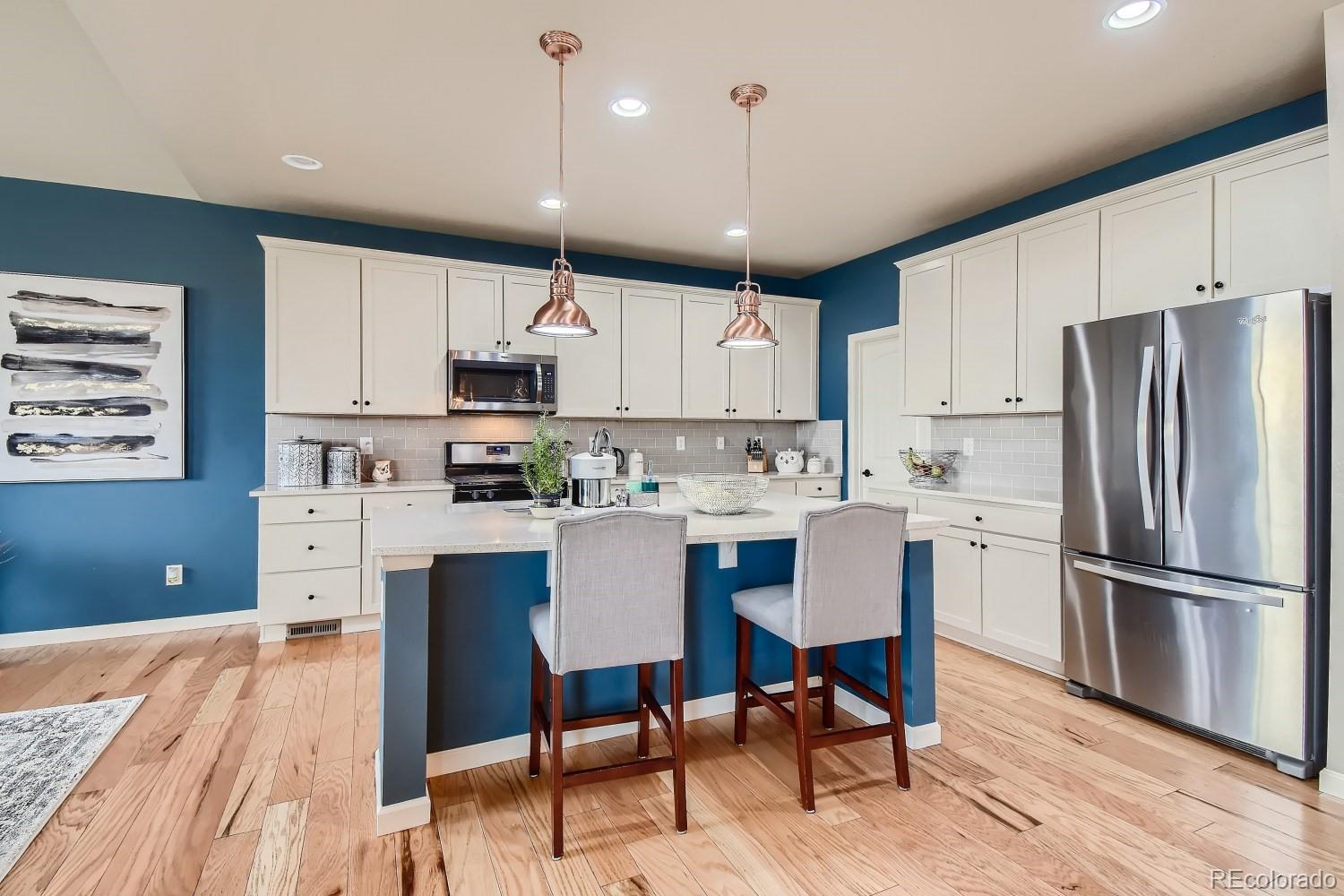 16035 Newark Lane Brighton, CO 80602 - Photo 10 of 40 a kitchen with stainless steel appliances granite countertop a refrigerator a sink dishwasher a stove and white cabinets with wooden floor