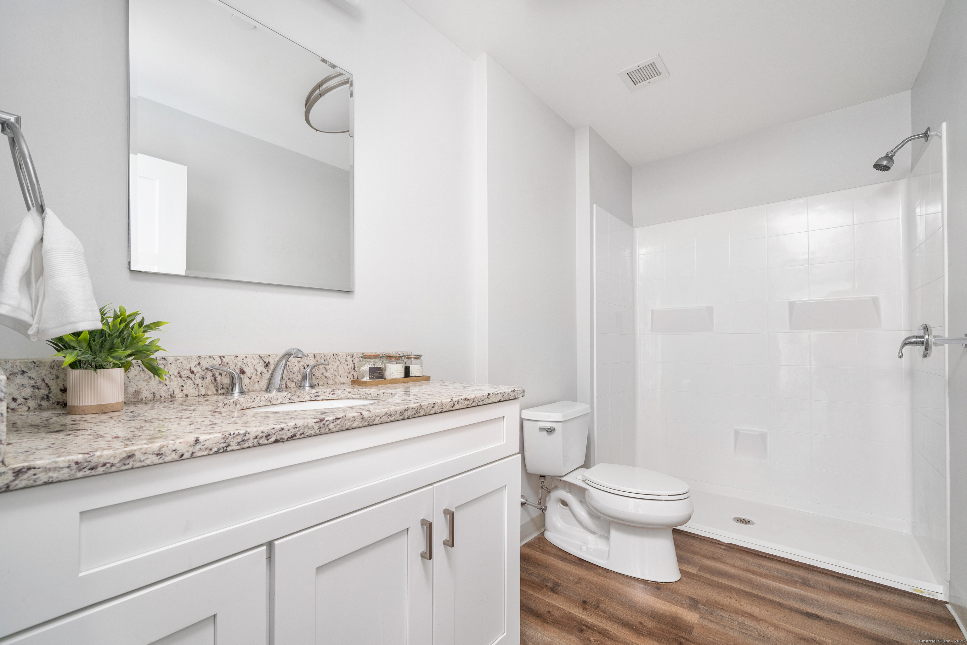170 Ridge Road, Unit 104 Wethersfield, CT 06109 - Photo 15 of 23 a bathroom with a granite countertop sink a toilet and a mirror