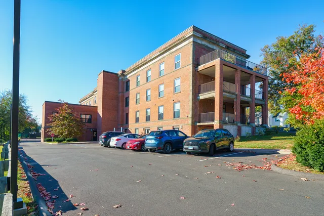 a front view of multi story residential apartment building with yard