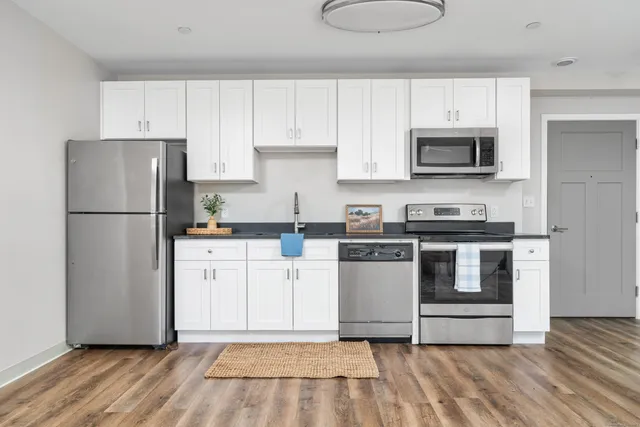 a kitchen with white cabinets and stainless steel appliances