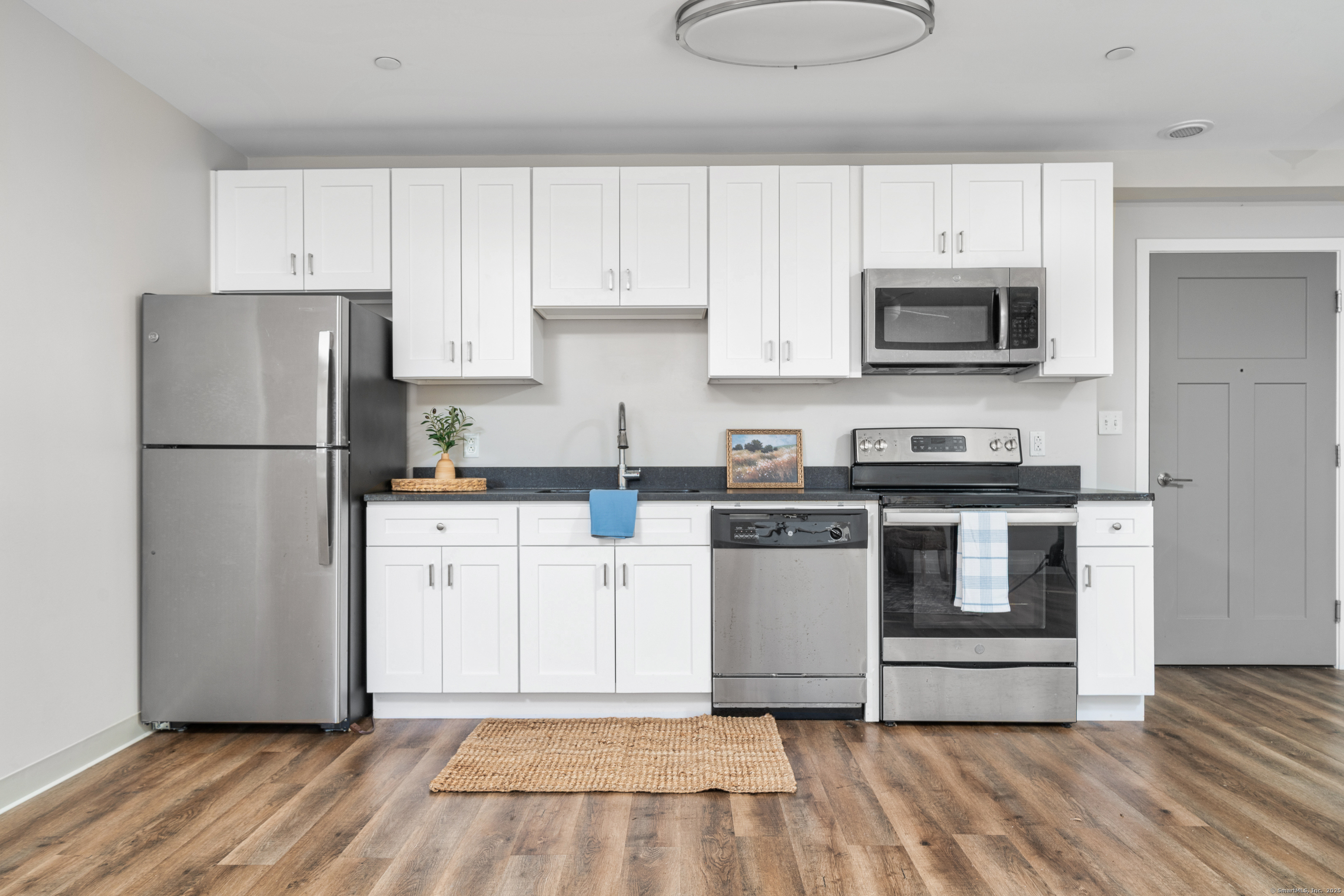 170 Ridge Road, Unit 104 Wethersfield, CT 06109 - Photo 5 of 23 a kitchen with white cabinets and stainless steel appliances