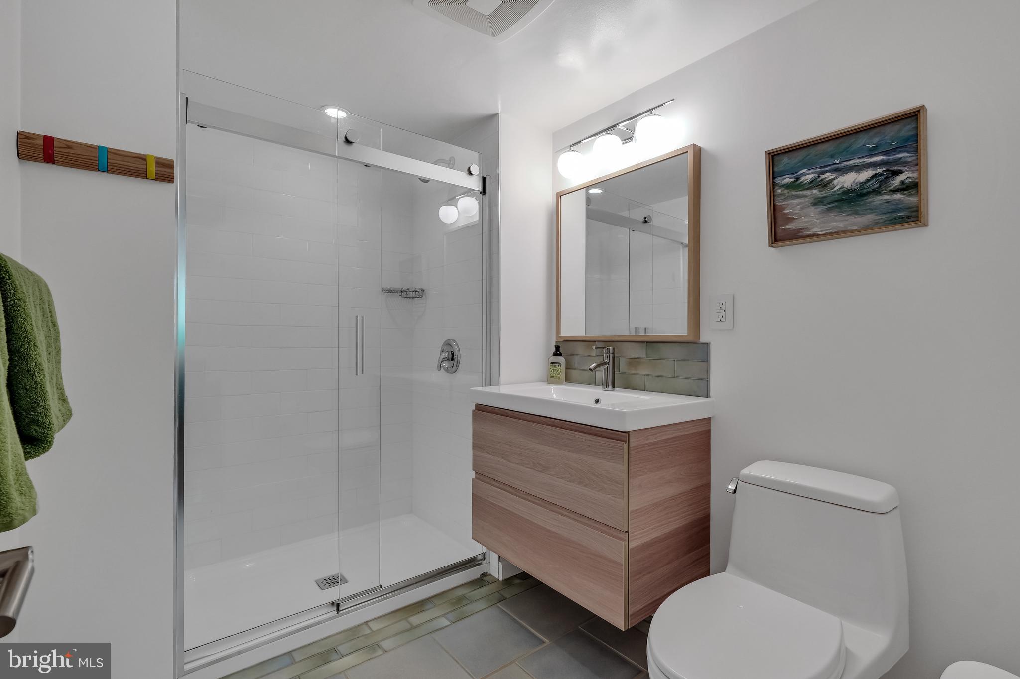 8303 Still Spring Court Bethesda, MD 20817 - Photo 39 of 56 a bathroom with a granite countertop toilet sink and shower