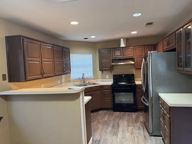 a kitchen with kitchen island a sink stainless steel appliances and cabinets