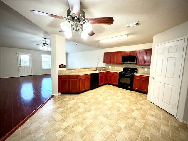 a large kitchen with stainless steel appliances granite countertop a sink and cabinets