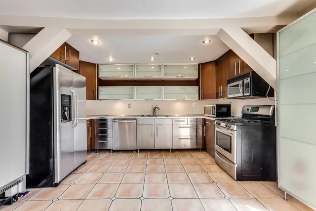 a kitchen with stainless steel appliances granite countertop a refrigerator and a stove