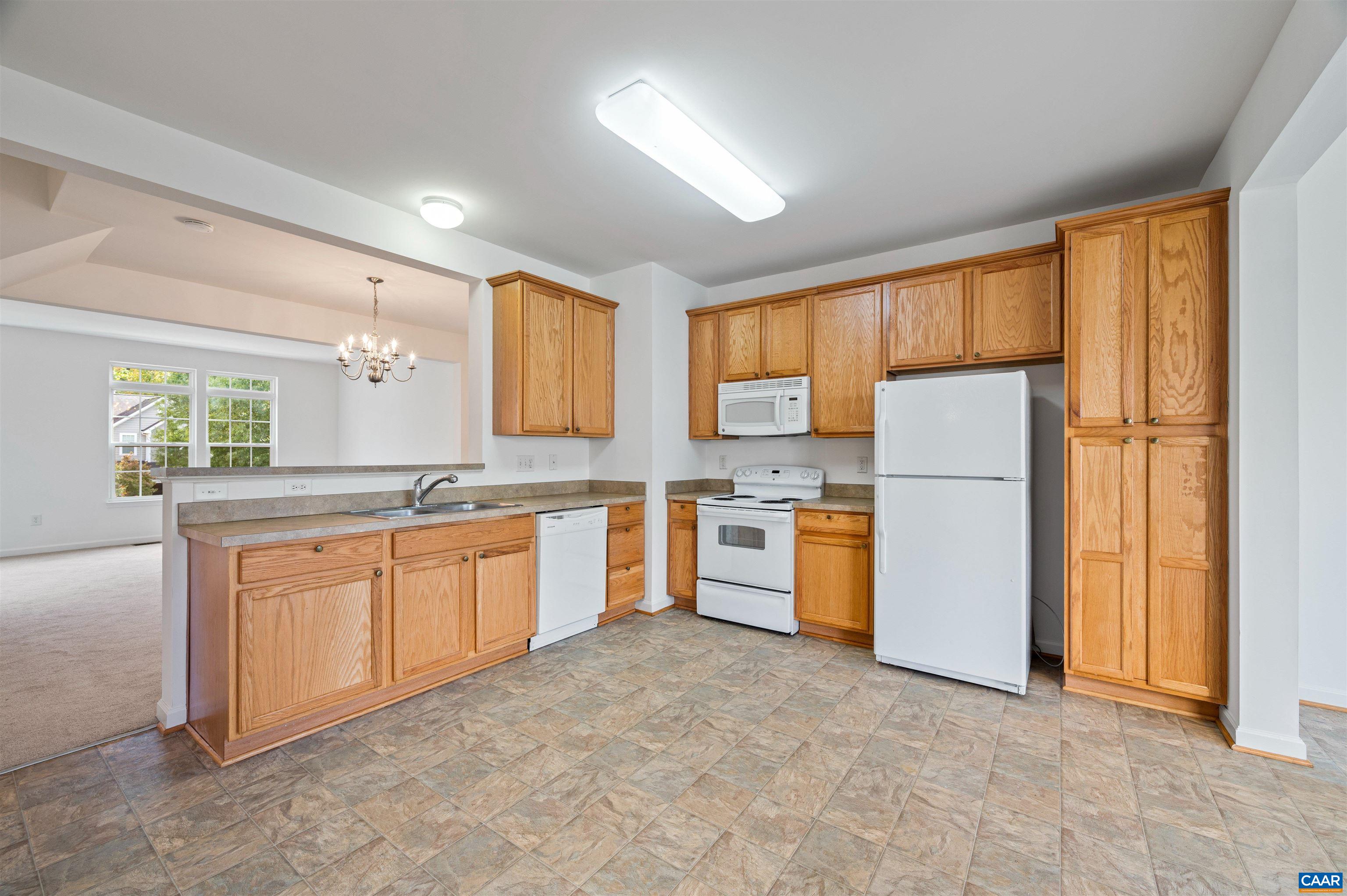 709 Rainier Road Charlottesville, VA 22903 - Photo 21 of 53 a large kitchen with a refrigerator a counter space and a window